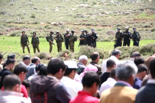 srail askerleri namaz klan Filistinlileri izliyorlar.