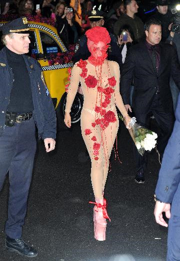 Y�z�n� gizledi�i k�rm�z� bir t�l�n ard�ndan hayranlar�n� selamlayan Lady Gaga salona girdi.
