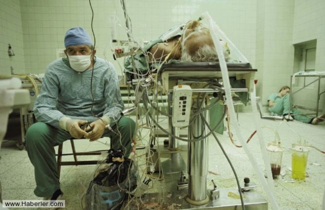 LK BAARILI KALP NAKL / Fotoraf: J. Steinfeld / Dr. Zbigniew Religa, 23 saat sren baarl kalp nakli ameliyatnn ardndan hastasnn yaam deerlerini monitrden izliyor. Asistan yorgunluktan bitkin dm, ameliyathanenin kesinde uyuyor.
