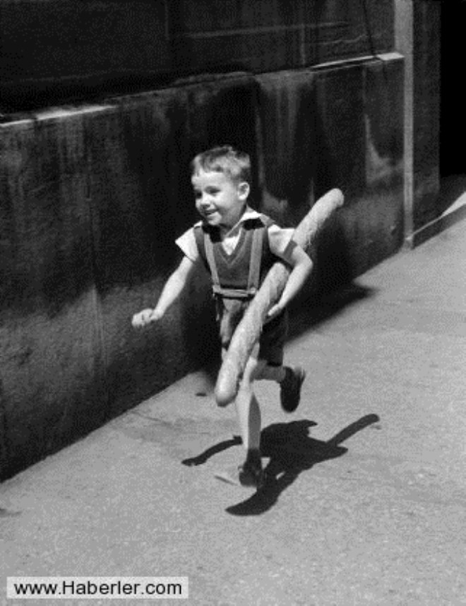 KK PARSL / Fotoraf: Willy Ronis / 1952 ylndan bu fotoraf, kk bir Parisli ocuu elinde Franszlara zg baget ekmei ile koarken gsteriyor.
