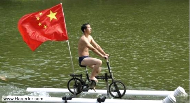 Liu Wanyong in bayran kendi icad olan su zerinde giden bisikletin arkasnda gururla dalgalandryor. Wanyong