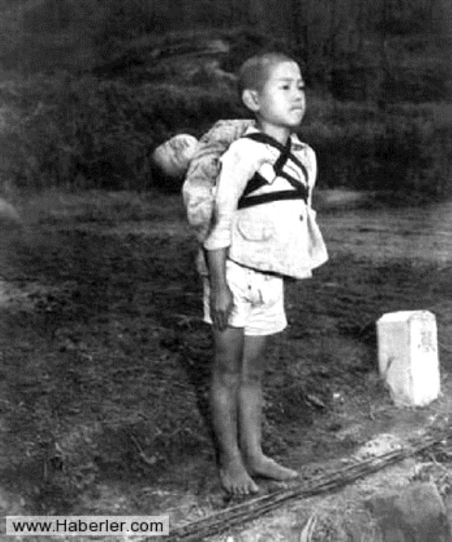 Srtnda tayarak kardeinin cansz bedenini yaklmas iin getiren Japon ocuk hazrolda dikilirken. (1945)
